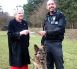 Joan Bedford-Lane handing Sgt Mick Hart and Cairo a cheque