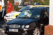 Breakdown truck, police car, black Rover and brick wall